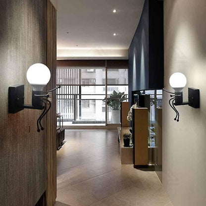 Universo - Applique da Parete Decorativo a Forma di Omino - Lampada da Muro in Metallo con Attacco E27 per Arredo Casa Soggiorno Ingresso (Omino Seduto Nero)